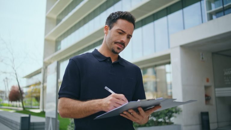 técnico revisando fachada y documentación de una finca residencial en Barcelona