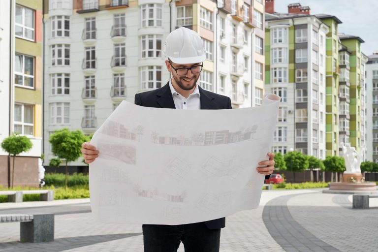 arquitecto técnico revisando planos y un informe ITE junto a una fachada residencial de Barcelona