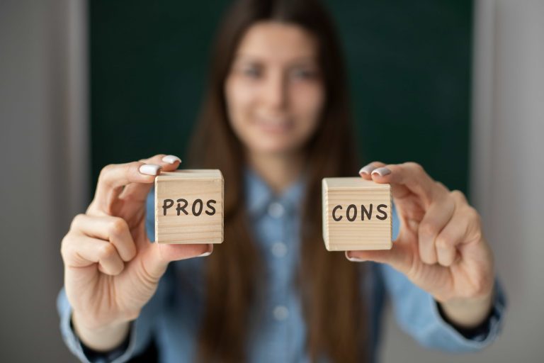 Imagen de una mujer con dos cubos de madera que sujeta con las manos. En uno pone PRO y en el otro CON
